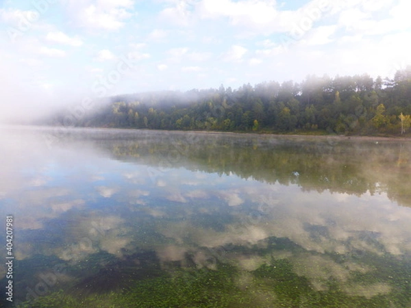 Fototapeta Algae and clouds in the Volga River. And there's a fog over the river