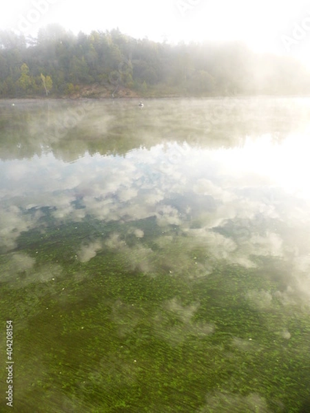 Fototapeta Algae and clouds in the Volga River. And there's a fog over the river