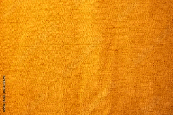 Obraz Golden yellow background from a textile material with pattern, closeup.