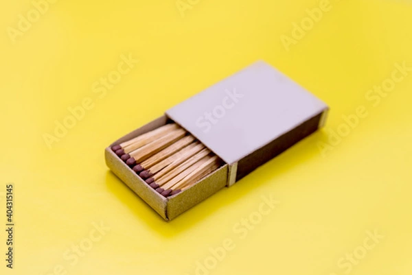 Fototapeta matchbox on a yellow background, wooden matches for a fire