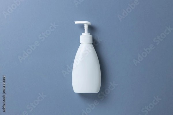 Fototapeta White bottle with hand soap, shower gel or body cream on gray background, mock up with place for text or copy space. Personal hygiene, skin care concept. Horizontal. Minimal style. Flat lay, top view