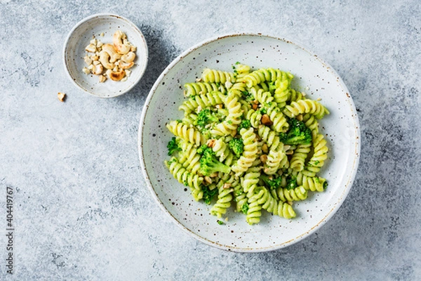 Fototapeta Vegetarian green pasta with broccoli and cashew nuts. Vegetarian healthy food. Top view. copy space