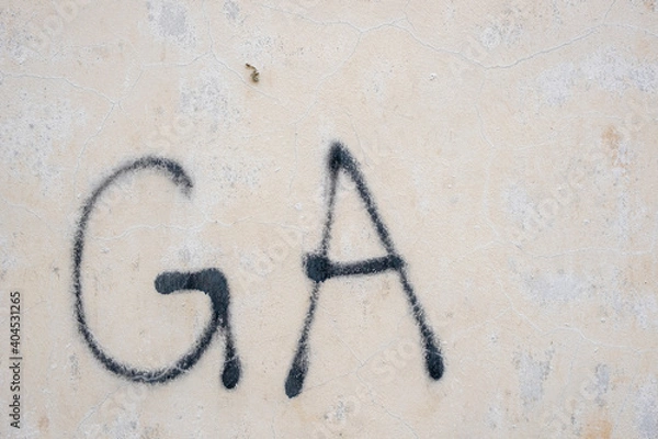 Obraz White painted aged, grunge wall texture with the letters G and A in spray paint , background. Stock Photo.