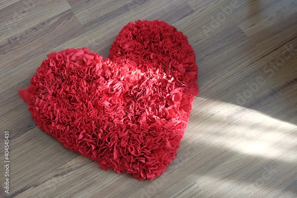 Fototapeta Heart shape doormat, in top view, red color, on wood floor with natural sunlight