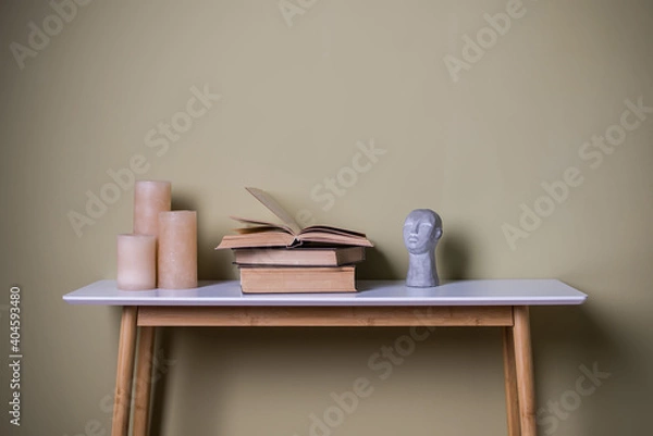 Fototapeta Books and candles on a wooden table. Element of home decor