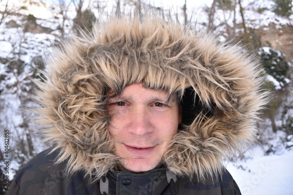 Fototapeta Close portrait of man in jacket and hood in snowy area after storm. Scene after the snowstorm called Filomena in Spain. Munilla, La Rioja.