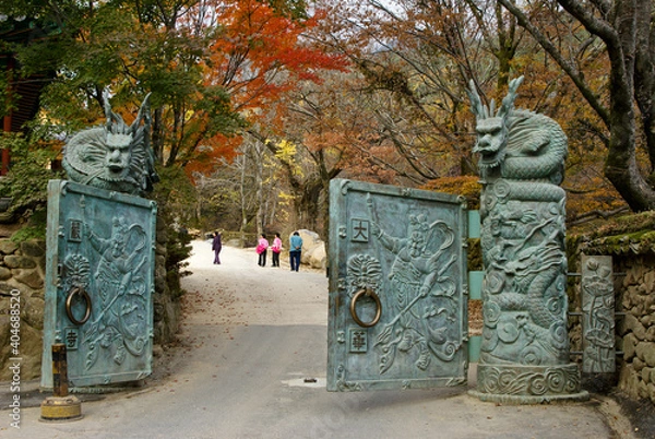 Fototapeta Under autumn colors, an ornate bronze gate opens into Hwaeomsa (Hwaeom-sa) Buddhist temple in South Korea's Jirisan National Park.