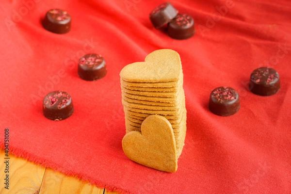 Fototapeta Pile of Valentine's day cookies with heart shape isolated on red with chocolates on the background. Valentine's day and love concept. Selective focus