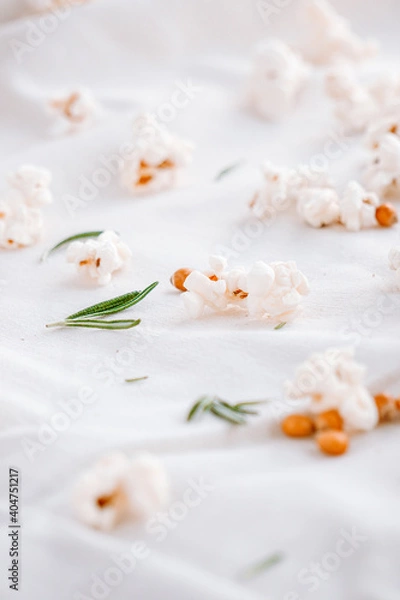 Fototapeta Popcorns isolated on white with rosemary. Close up view. Selective focus