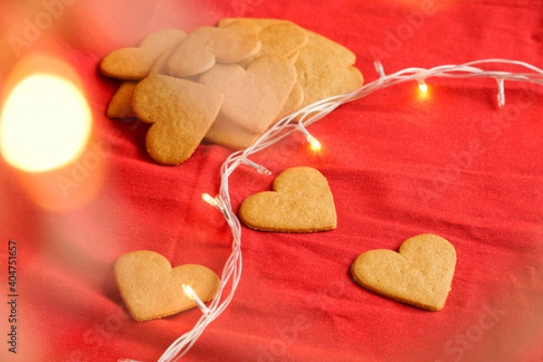 Fototapeta Valentine's day cinnamon cookies background isolated on red with ethereal lights. Valentine's day and love concept. Selective focus