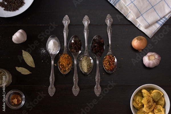Fototapeta different spices and spices on a spoon on a dark wood background