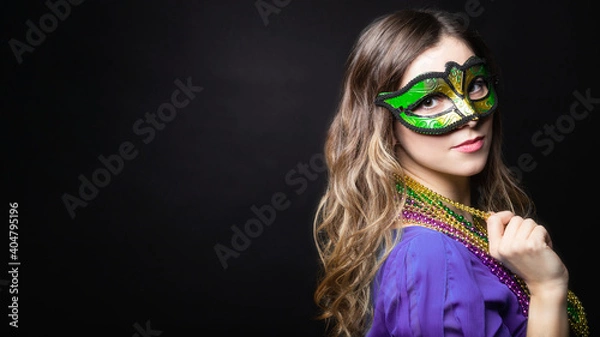 Obraz Mardi gras party, masquerade. Woman with a carnival mask and beads on the black background with copy space, banner