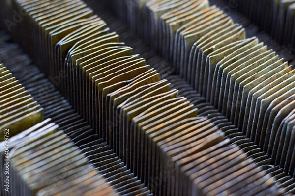 Fototapeta Plate-fin heat exchanger surface closeup texture. Old heat exchange equipment bent plates with traces of corrosion rust. Selective focus industrial background, with copyspace.