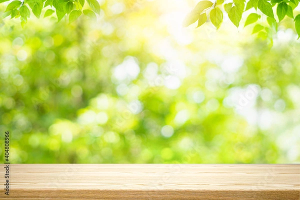 Fototapeta Empty wooden table with blurred green background with a country outdoor theme,Template mock up for display of product