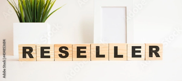 Fototapeta Wooden cubes with letters on a white table. The word is RESELLER. White background.