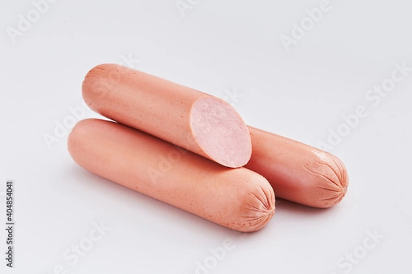 Fototapeta Sausages on a white background. Pieces of sliced sausages isolated