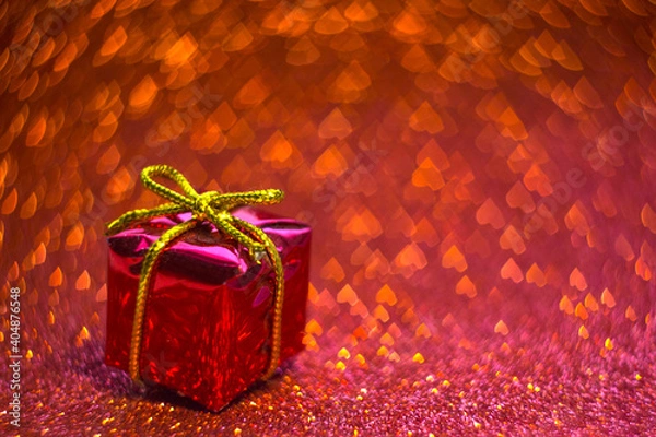 Obraz gift box with ribbon on red glittering background