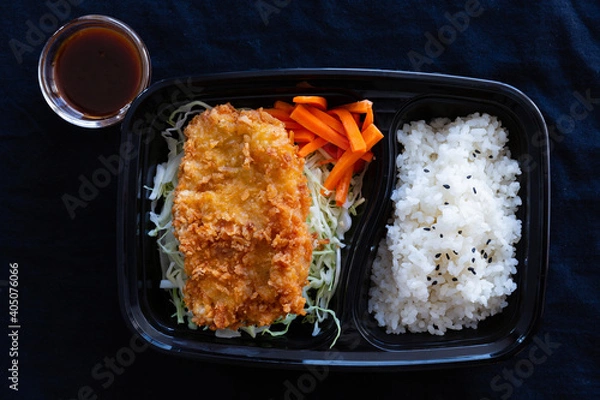 Fototapeta Japanese deep fried pork with rice or tonkatsu set in a lunch box on black background.