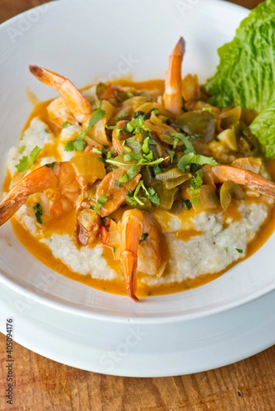 Fototapeta Shrimp and Grits. Grits and old bay seasoned jumbo shrimp topped with spices and micro greens. Classic American Diner Style Breakfast or Brunch menu item. Traditional low country southern staple. 