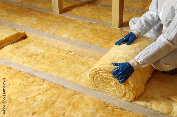 Fototapeta Worker insulate the attic with mineral wool