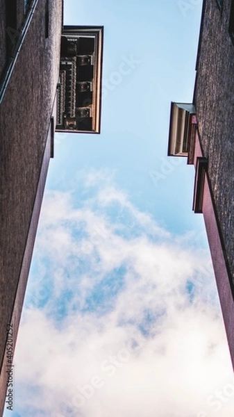 Obraz clouds in sky between buildings