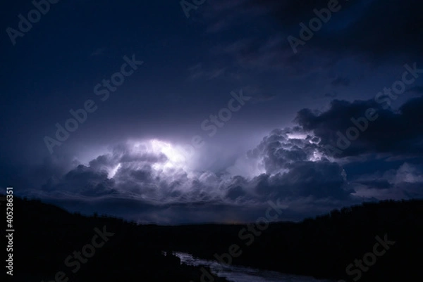Fototapeta Strong lightning in and behind big towering thunderclouds