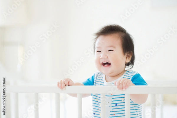 Obraz ベビーベッドで笑う赤ちゃん  