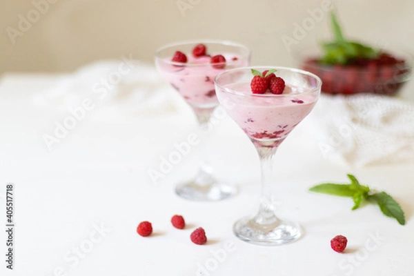 Fototapeta Delicious dessert, cheesecake with fresh raspberries and butter cream mousse in glass. Copy space, flat lay