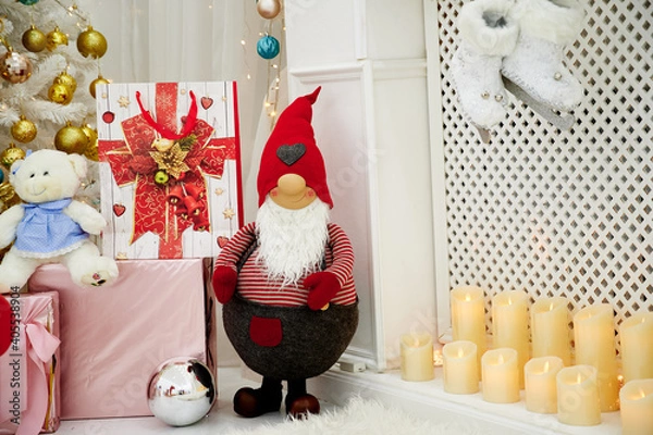 Obraz Christmas gnome with gifts by the fireplace under the Christmas tree