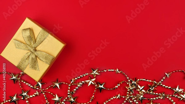 Obraz Gift box with a gold bow and gold decoration at the bottom of the frame. Banner. Greeting card for New Year, Christmas, Thanksgiving, Mother's Day, Birthday. A place for a creative concept