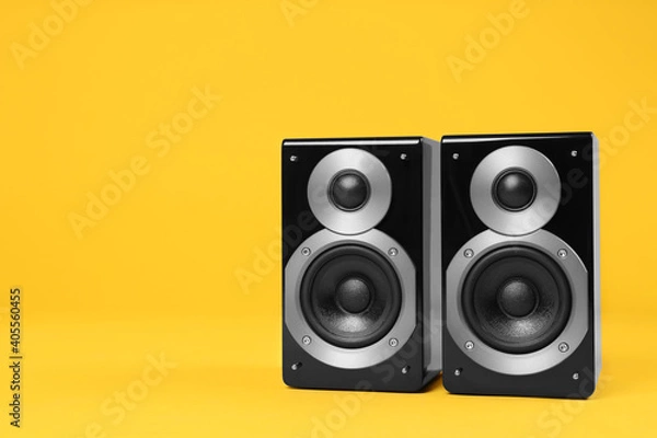 Fototapeta Modern powerful audio speakers on yellow background, space for text