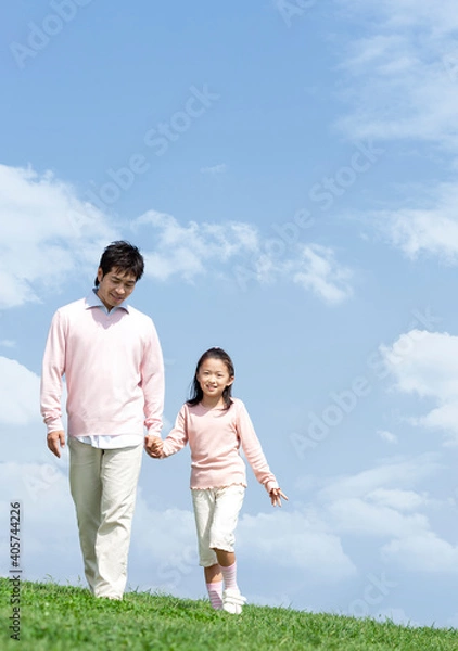 Fototapeta 手をつないで歩く親子