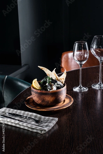 Fototapeta Wooden plate with food served on the table on black background