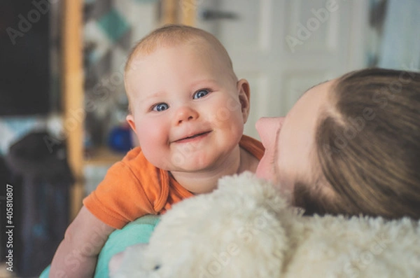 Fototapeta Mom and baby are resting and smiling while sitting on the couch