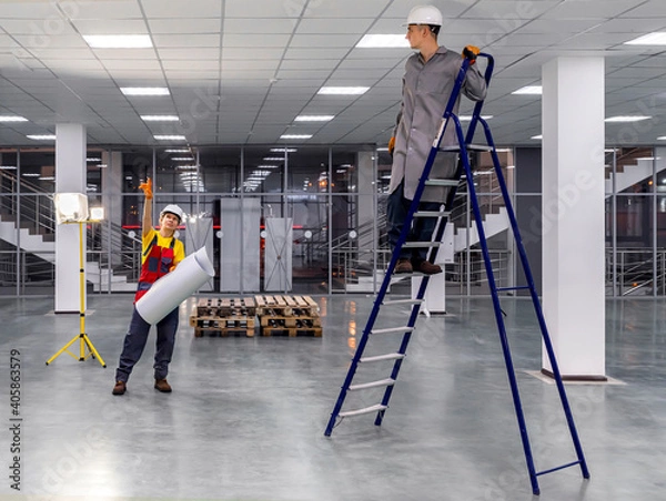 Fototapeta Workers on a ladder check the electrical wires on the ceiling. Workers in overalls check the correctness of the wiring under the ceiling in the office space. Check with the plan.