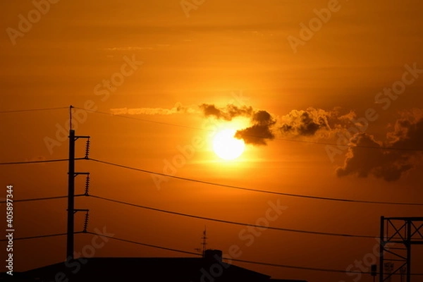 Fototapeta Sunset view Beautiful golden yellow sky in big cities,Power transmission system With the sky and the beautiful clouds in bright days.Golden sunset with poles and power lines