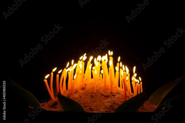 Fototapeta hand holding a burning candles in darkness with noise and grain effect bokeh.