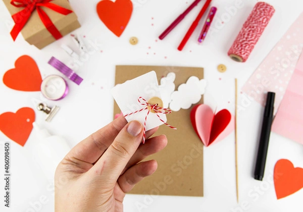 Fototapeta Valentine's Day. Instructions for making cards for Valentine's Day. Step 7 Cut out a trapezoid from white paper, tie a red thread and a button.