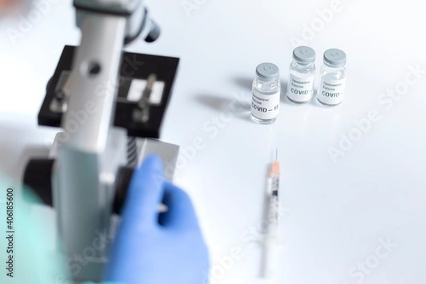 Fototapeta Covid-19 vaccine dose under a microscope.