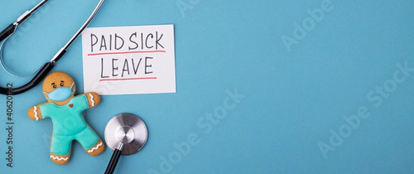 Obraz a gingerbread man in a mask and a medical phonendoscope with the inscription paid sick leave on a blue background