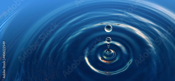 Fototapeta Clear blue water drop with rings and small waves.