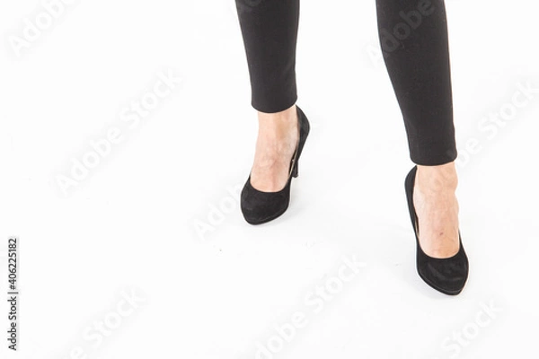 Obraz Close up view to female legs in black shoes and black leggings isolated on white background