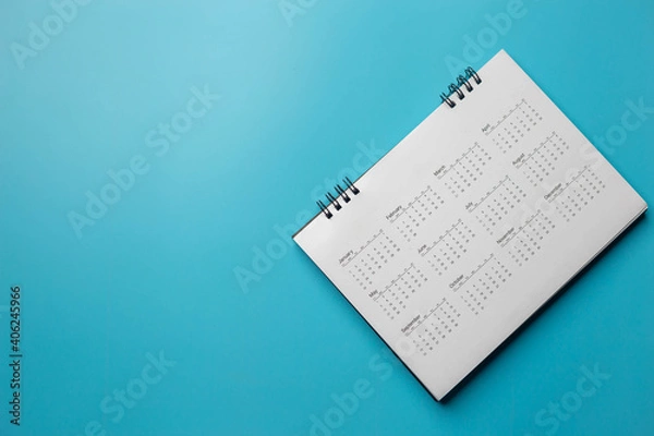 Obraz Calendar on solid blue background with copy space, business meeting schedule, travel planning or project milestone and reminder concept.