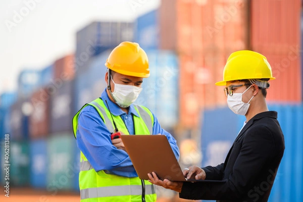 Fototapeta Engineer or Foreman Talk to an Asian businessperson about loading containers from a cargo ship.