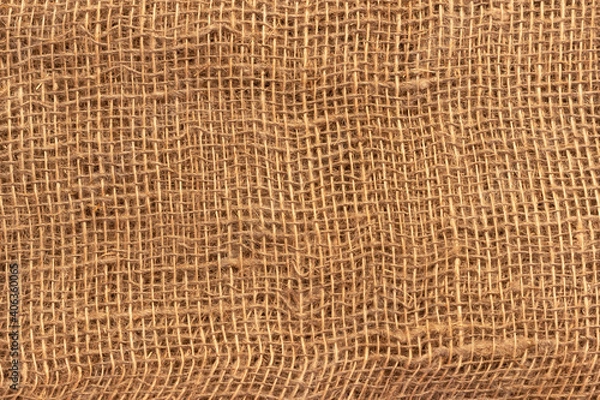 Fototapeta The texture of an uneven crumpled, roughly woven burlap.
