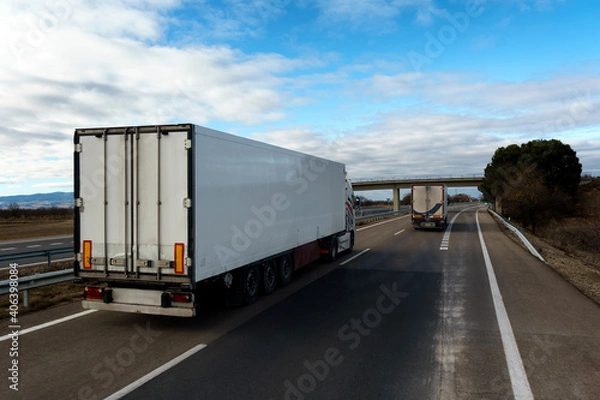 Fototapeta Camión frigorífico con temperatura controlada que transporta mercancías por carretera adelantando en la autovía.