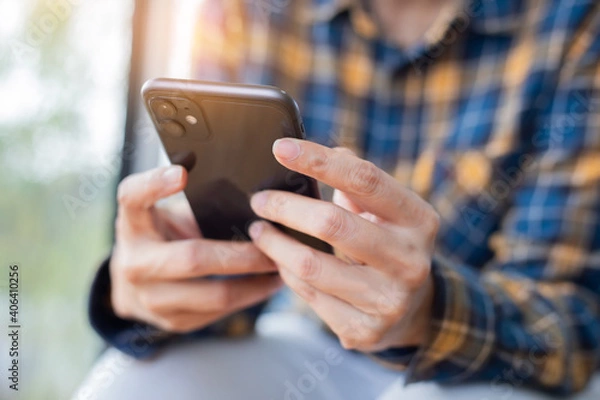 Fototapeta man work using cell phone hand holding mobile texting message contact us.chatting,search internet information in office.technology device communication connecting