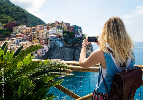 Fototapeta junge Frau fotografiert Manarola / Cinque Terre mit Smartphone