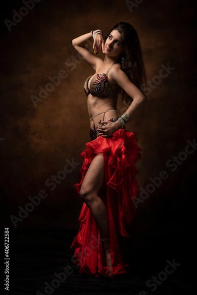 Obraz Oriental dancer with a saber. Belly dance. The brunette. Red.
