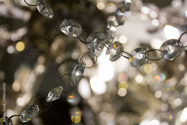 Fototapeta Shining garland of a hanging chandelier on a blurred background